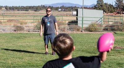Friends of the Children Central Oregon mentor Aaron Hinkley plays catch with one of the kids he mentors through the program while at the organization’s ranch outside Bend in 2023.  